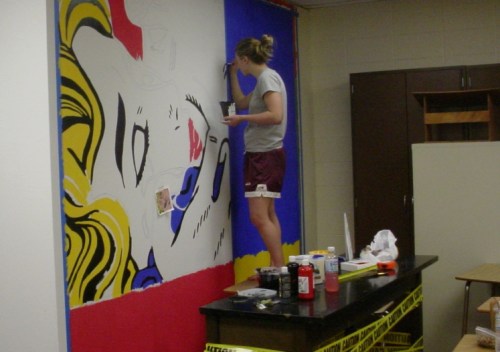 Caroline Bohler paints a Lichtenstein replica in June 2005.  Her work still brightens room S95.
